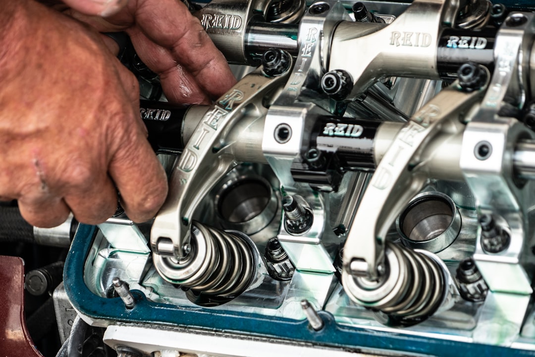 Professional automotive technician performing detailed engine work with precision tools and expertise